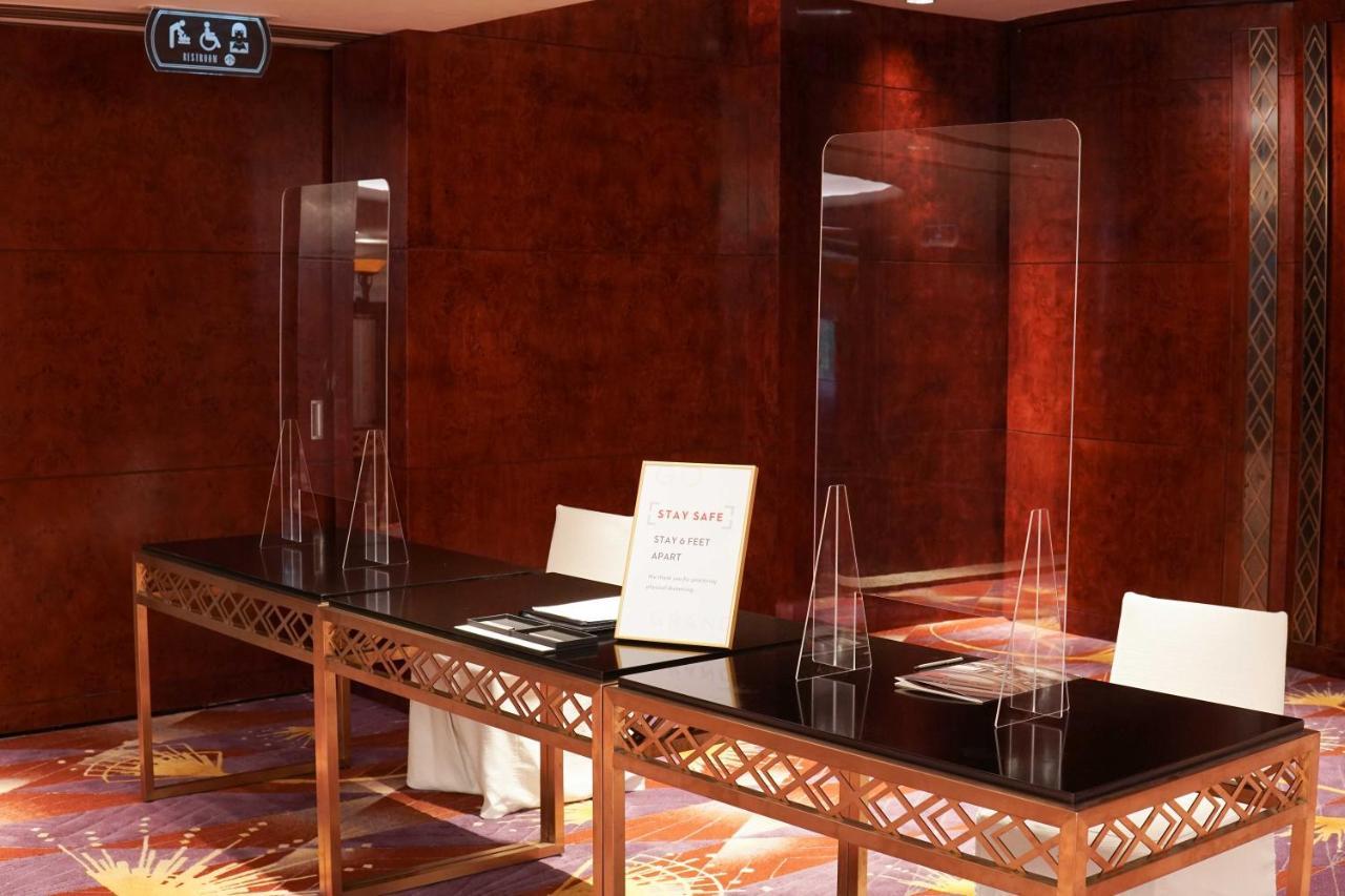 Grand Hyatt Hong Kong Hotel Exterior photo Plexiglass shield at a hotel reception desk